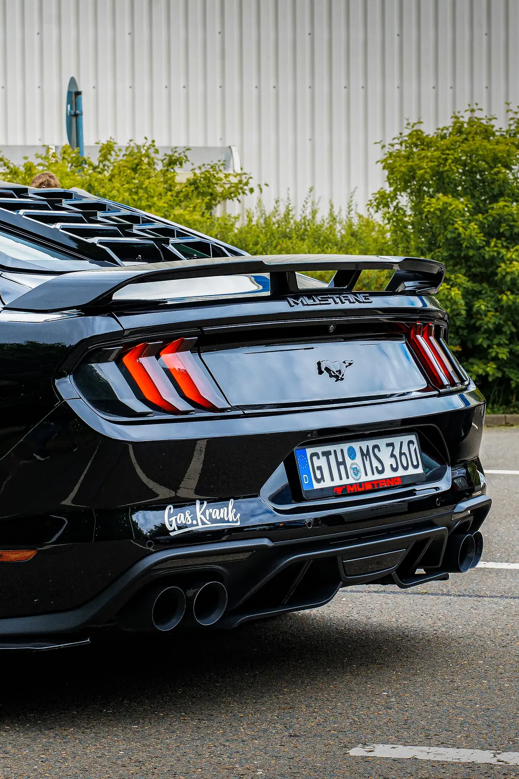 Heck eines schwarzen Mustangs mit Heckflügel und vier Endrohren