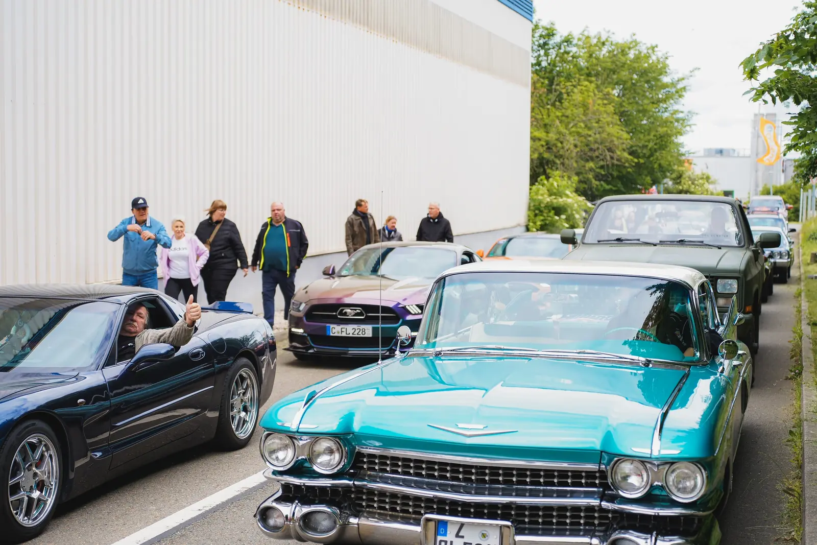 Türkiser Cadillac mit Heckflossen und eine Corvette in der Warteschlange