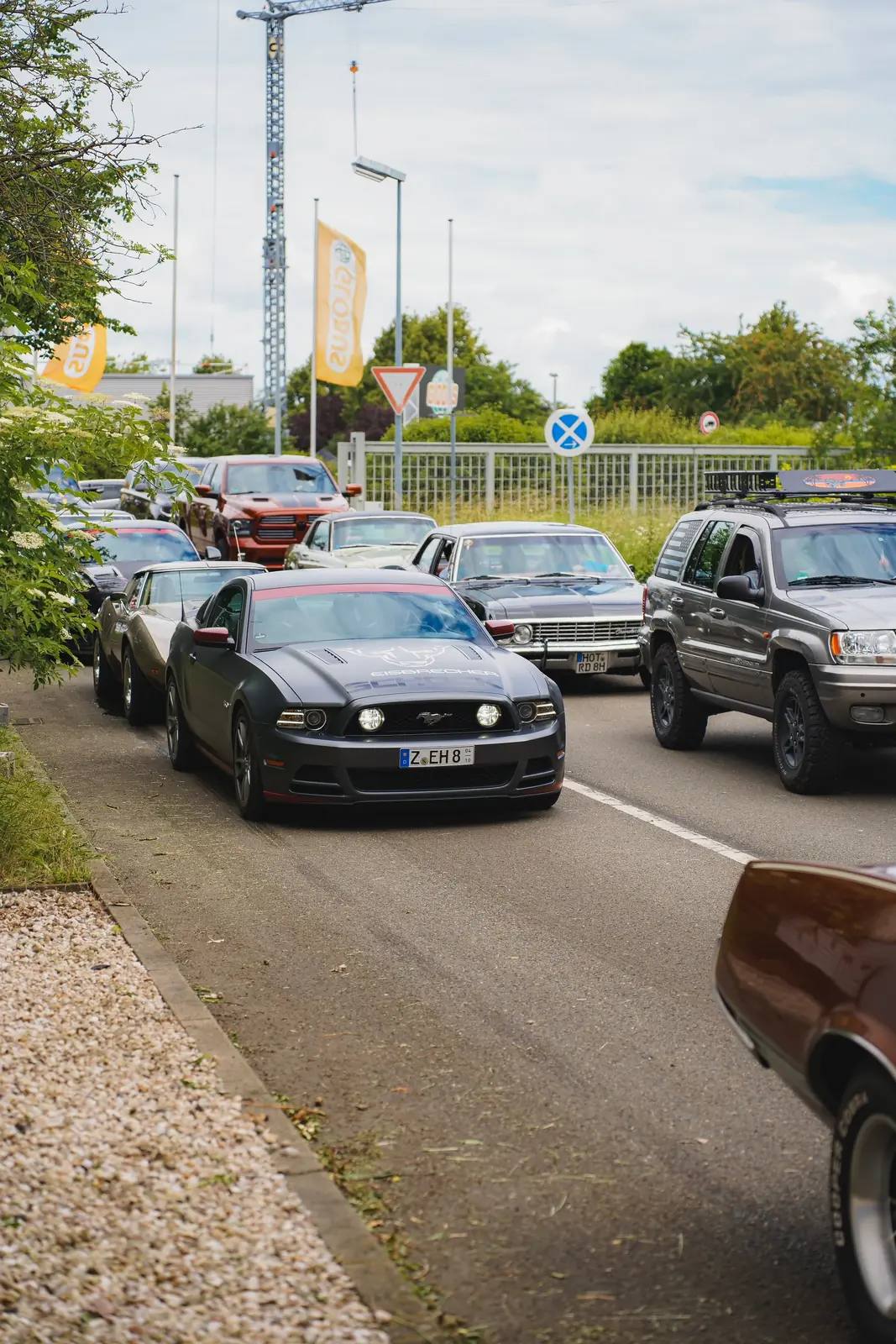 Schwarzer Mustang in der Zufahrt, dahinter weitere Wagen