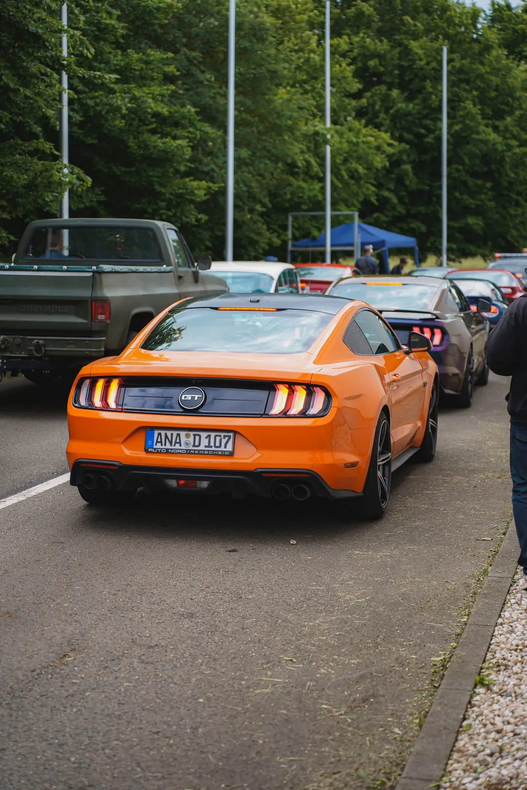Oranger Mustang von hinten in der Warteschlange