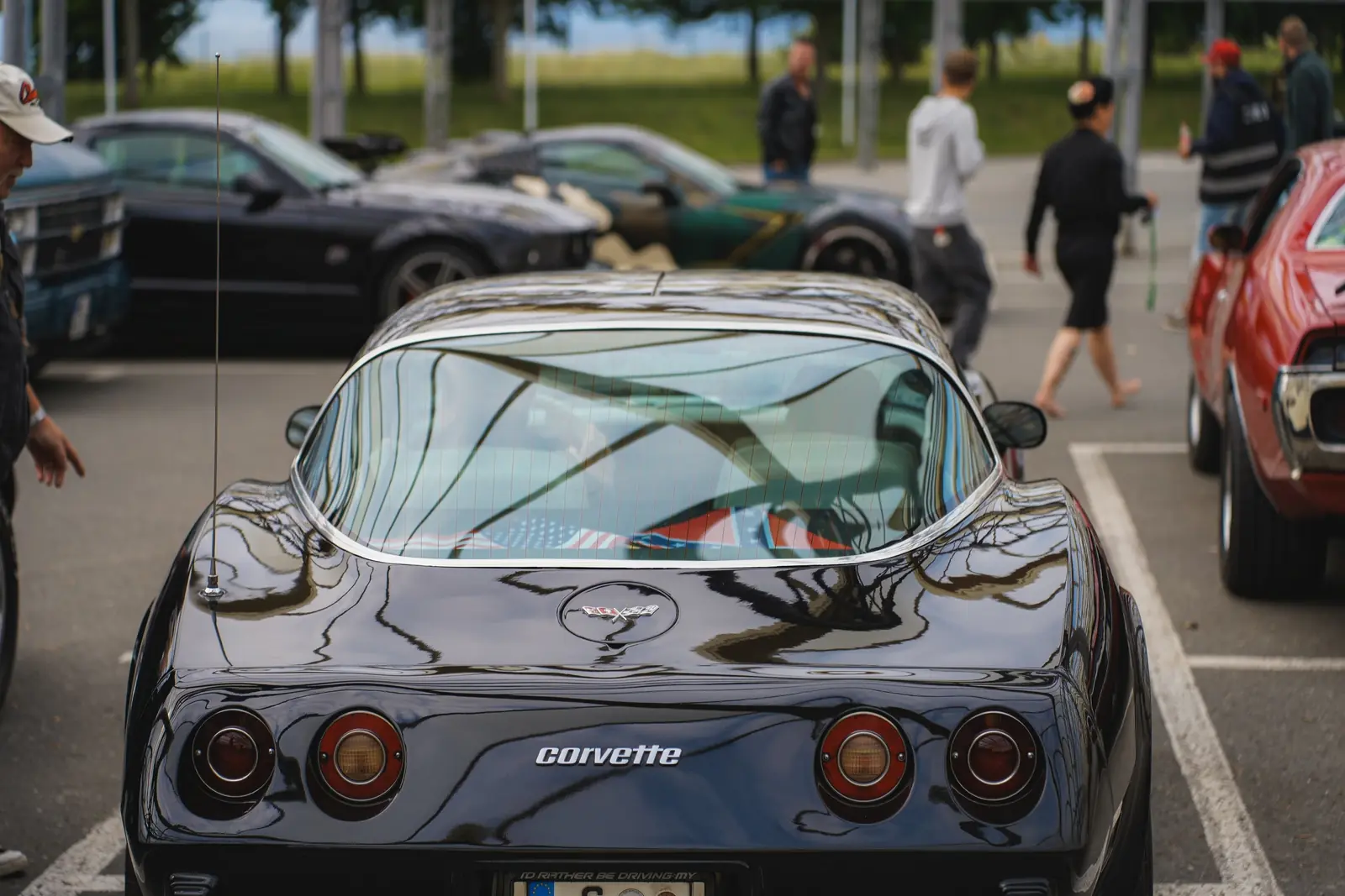 Schwarze Corvette von hinten, dahinter Besucher