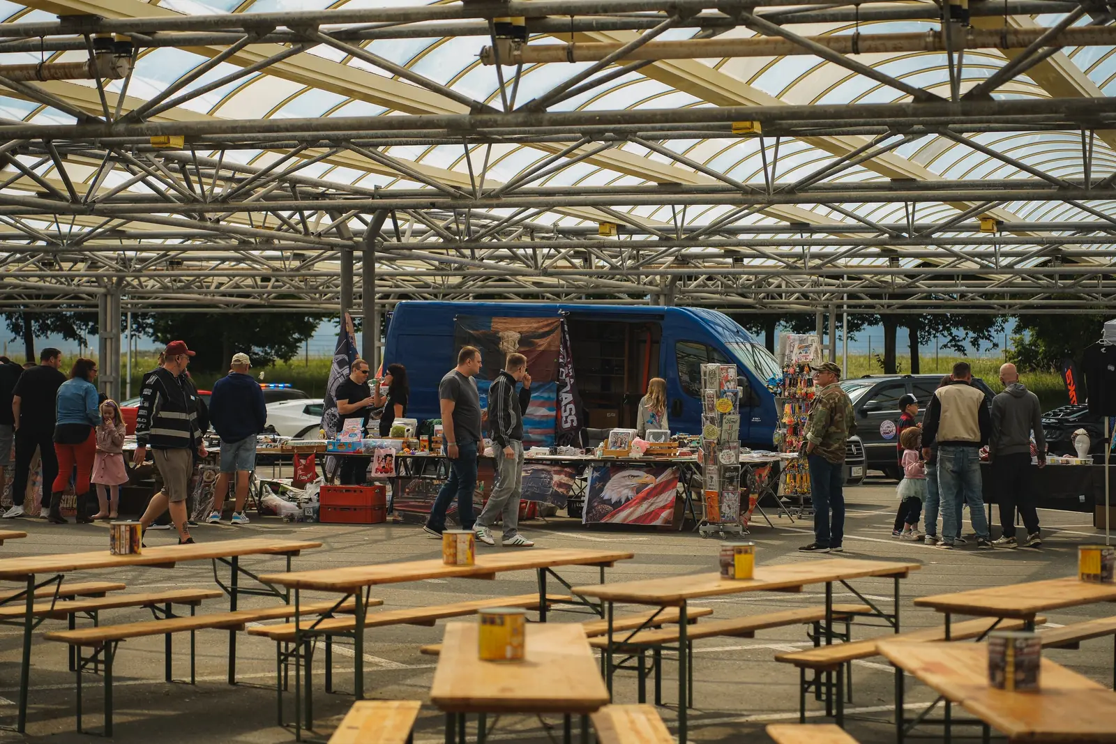 Biertische vor Händlerständen unter dem Glasdach