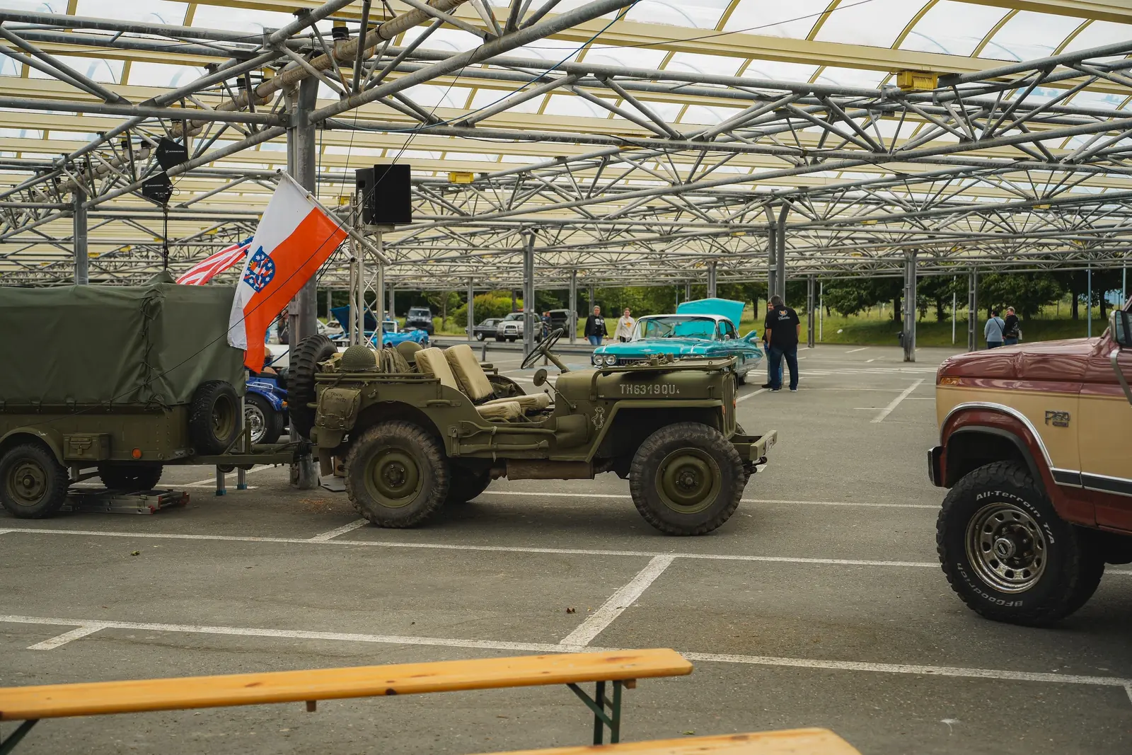 Willys-Jeep mit Anhänger unter dem Glasdach, darüber die Thüringer Fahne