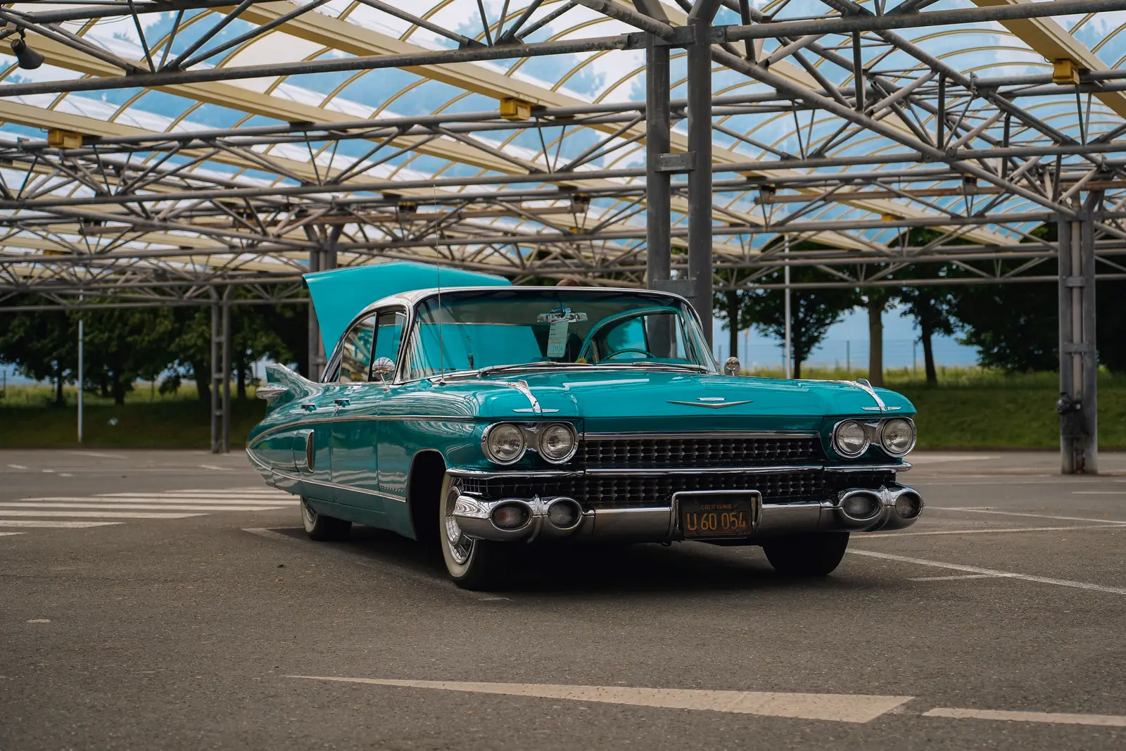 Türkiser Cadillac mit Heckflossen unter dem Glasdach