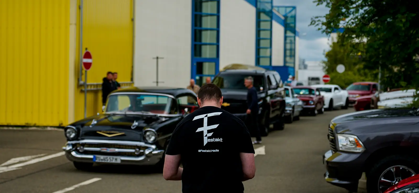 Besucher vor einem schwarzen Chevrolet Bel Air