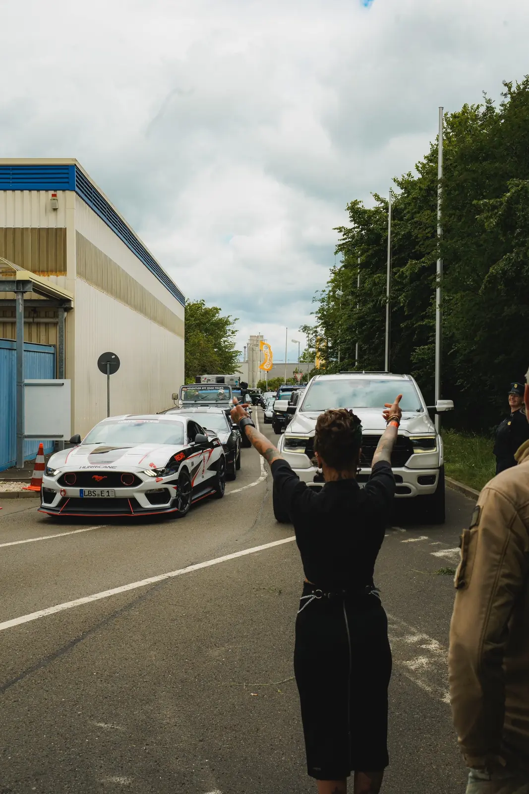 Frau in Uniform winkt einen weißen Mustang auf den Platz