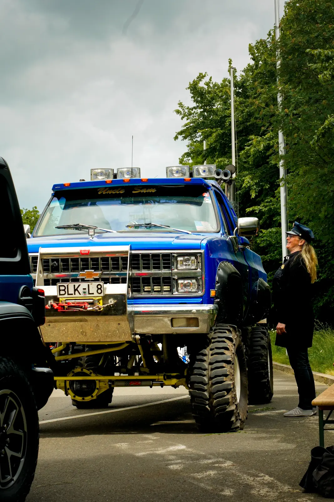 Blauer Chevrolet-Pick-up mit Riesenrädern an der Einfahrt