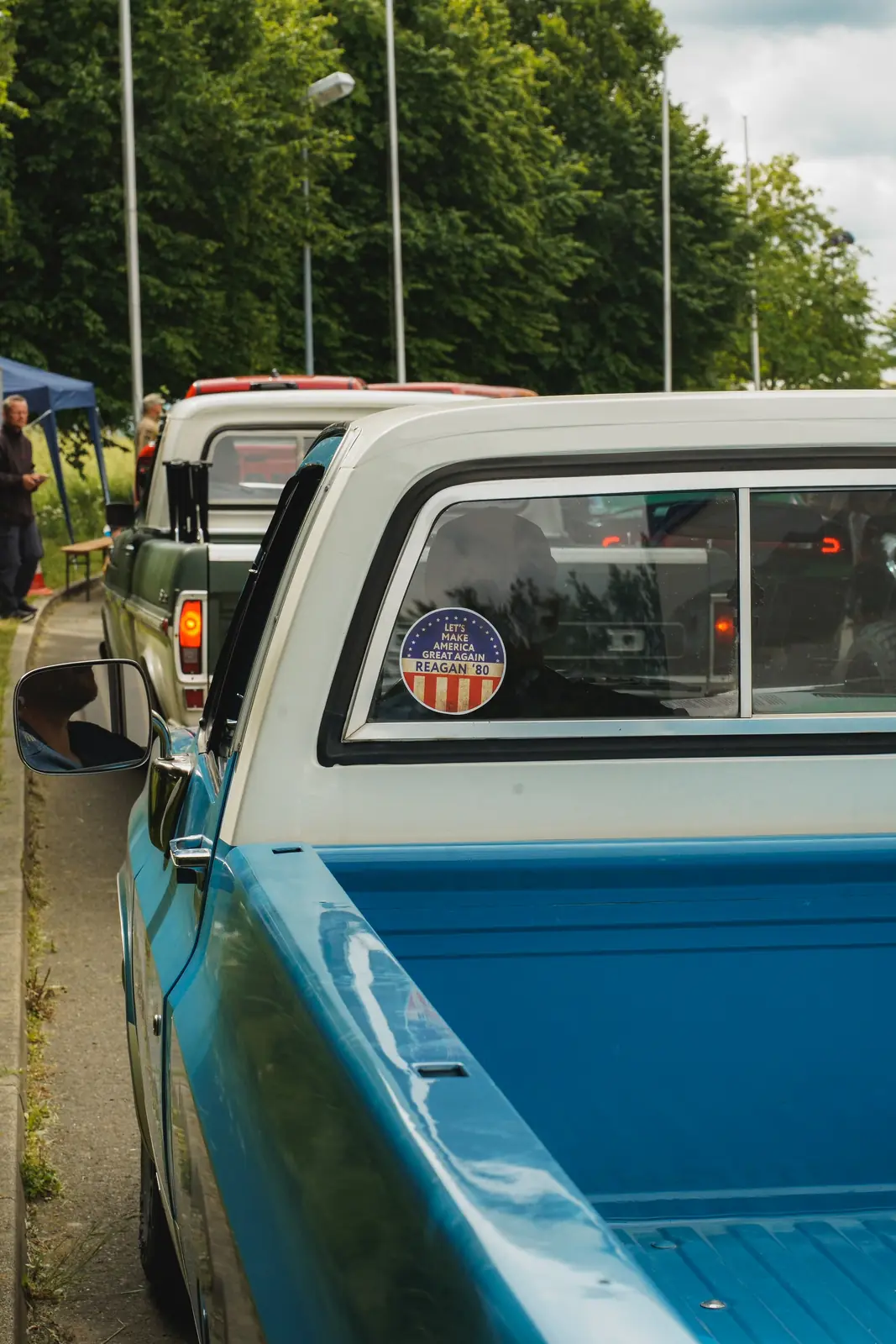 Blau-weißer Pick-up mit US-Aufkleber in der Heckscheibe