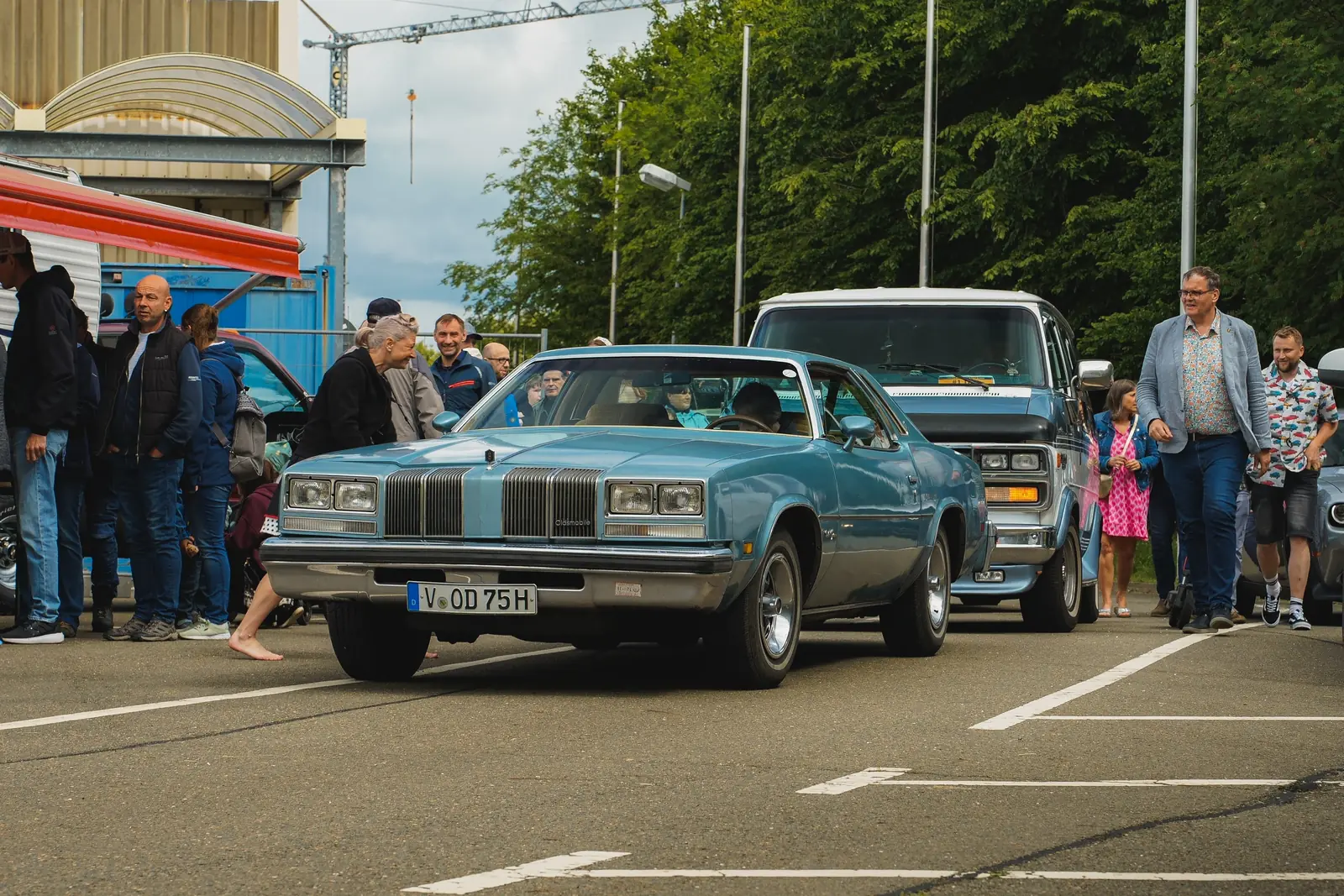 Hellblauer Oldsmobile aus den Siebzigern rollt an den Besuchern vorbei