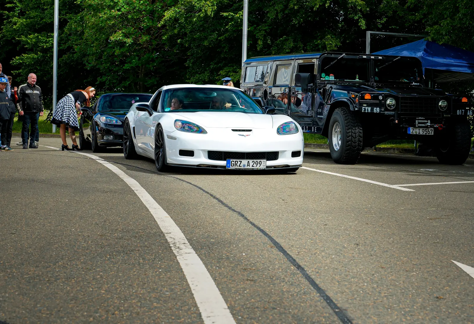 Weiße Corvette und schwarzer Hummer in der Zufahrt