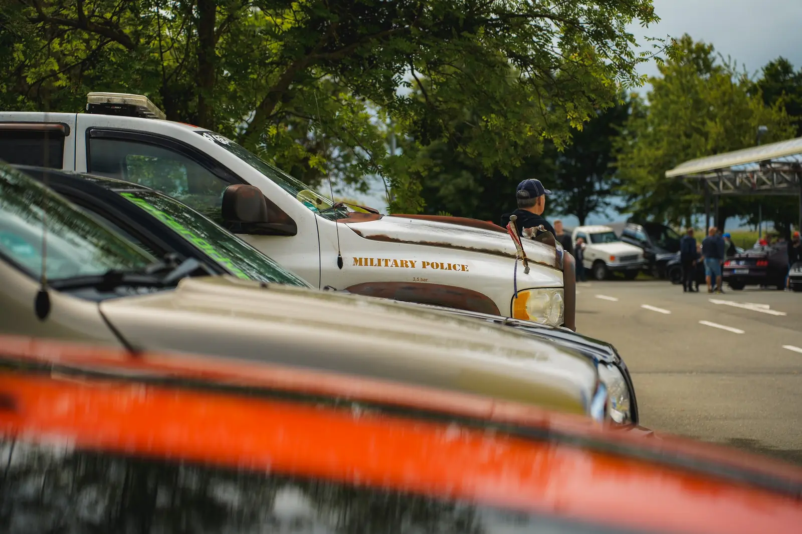 Pick-up im Military-Police-Look hinter unscharfen Motorhauben