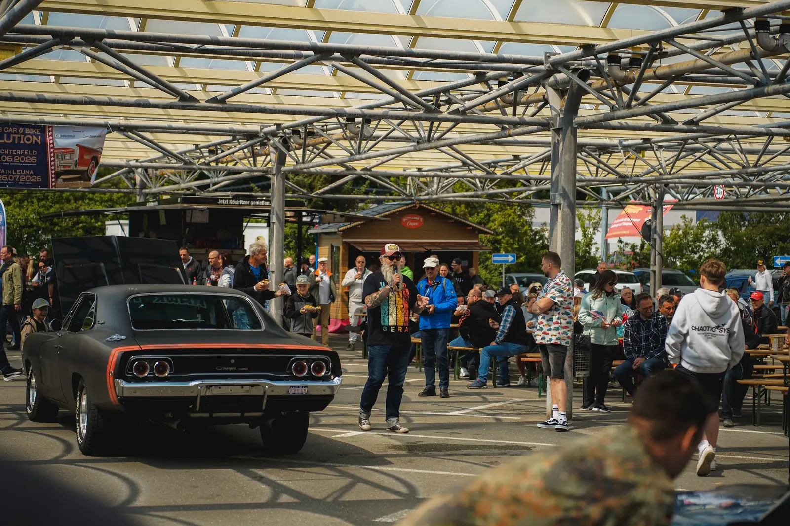 Grauer Dodge Charger aus den Sechzigern zwischen Besuchern unter dem Glasdach