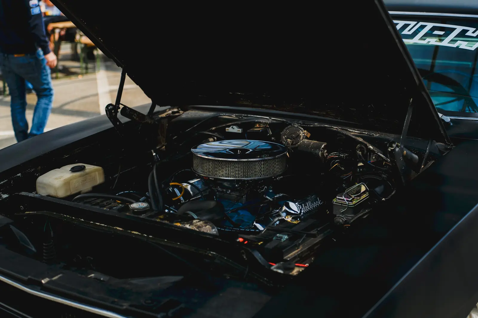 Verchromter Luftfilter im Motorraum eines schwarzen Wagens