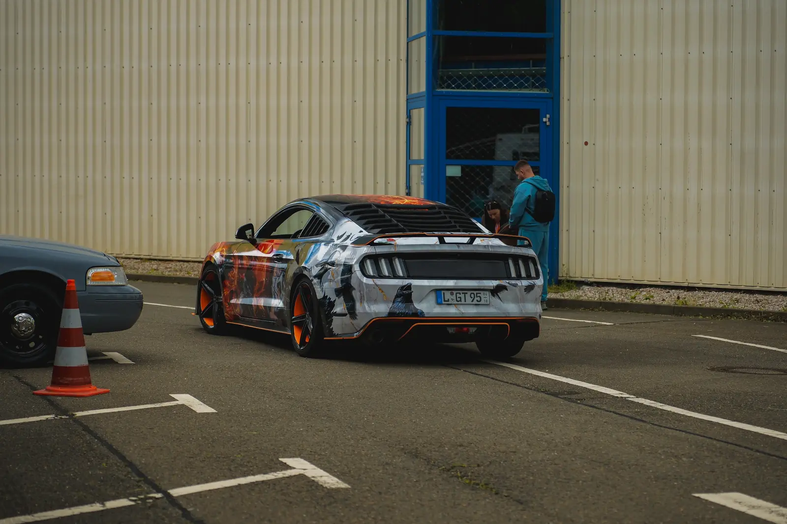 Mustang mit Comic-Folierung von hinten vor der Halle