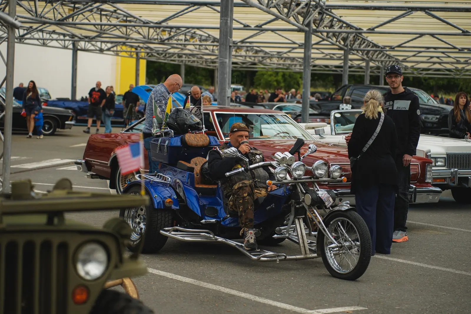 Blaues Trike mit US-Fähnchen, der Fahrer sitzt auf
