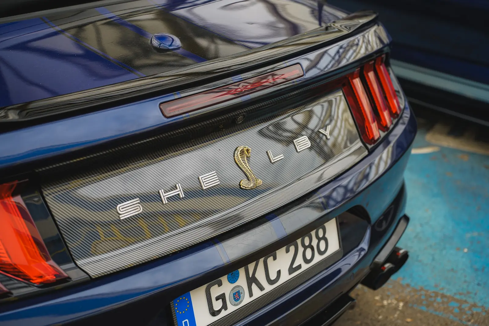 Shelby-Schriftzug mit Kobra am Heck eines blauen Mustangs