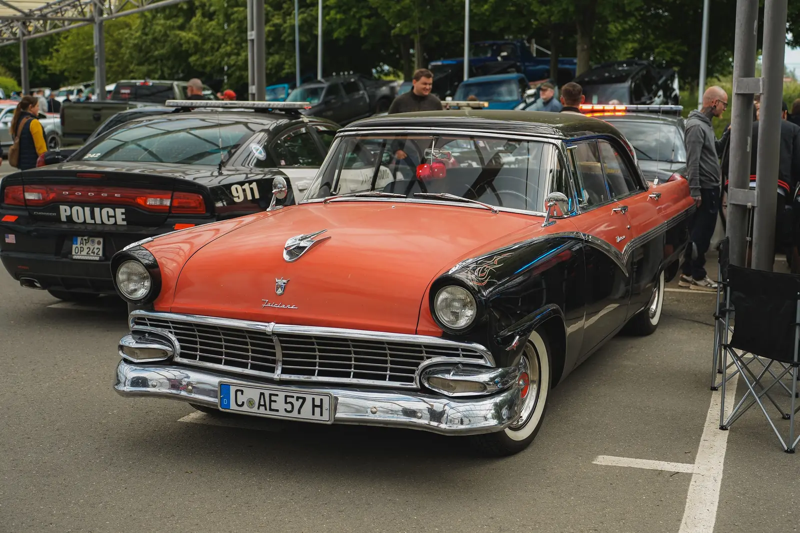 Rot-schwarzer Ford Fairlane aus den Fünfzigern, dahinter ein Polizei-Charger
