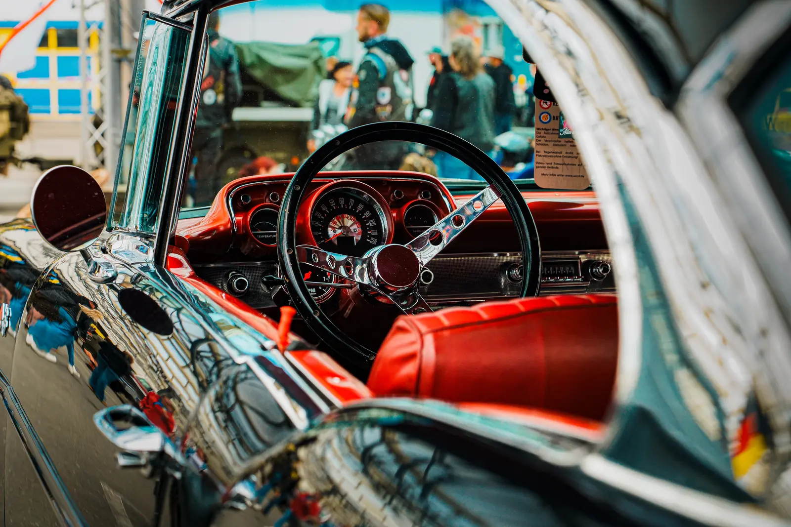 Rotes Interieur und verchromtes Lenkrad eines Oldtimers