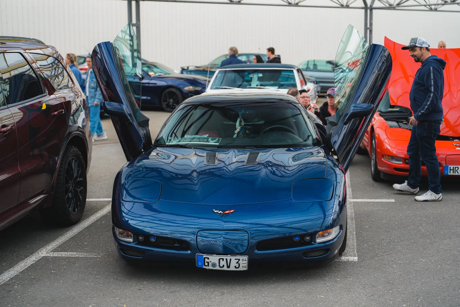 Blaue Corvette mit nach oben geöffneten Türen