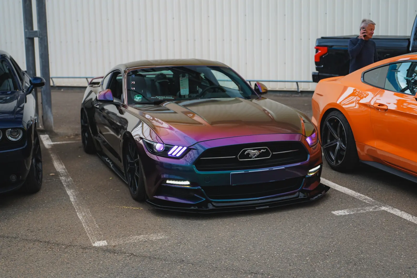 Mustang mit Farbwechsel-Lack neben einem orangen Mustang