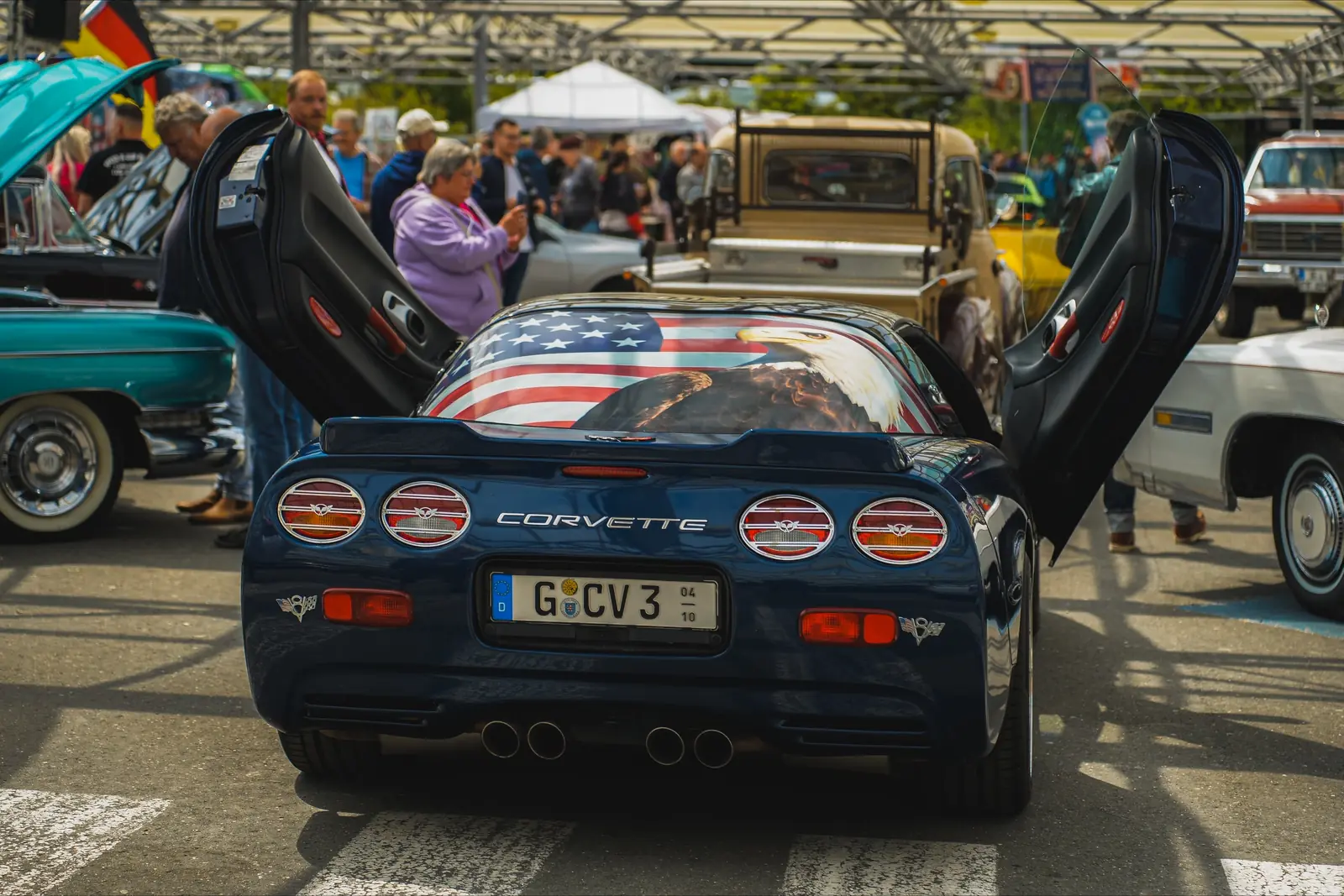 Blaue Corvette mit US-Flagge in der Heckscheibe und geöffneten Türen
