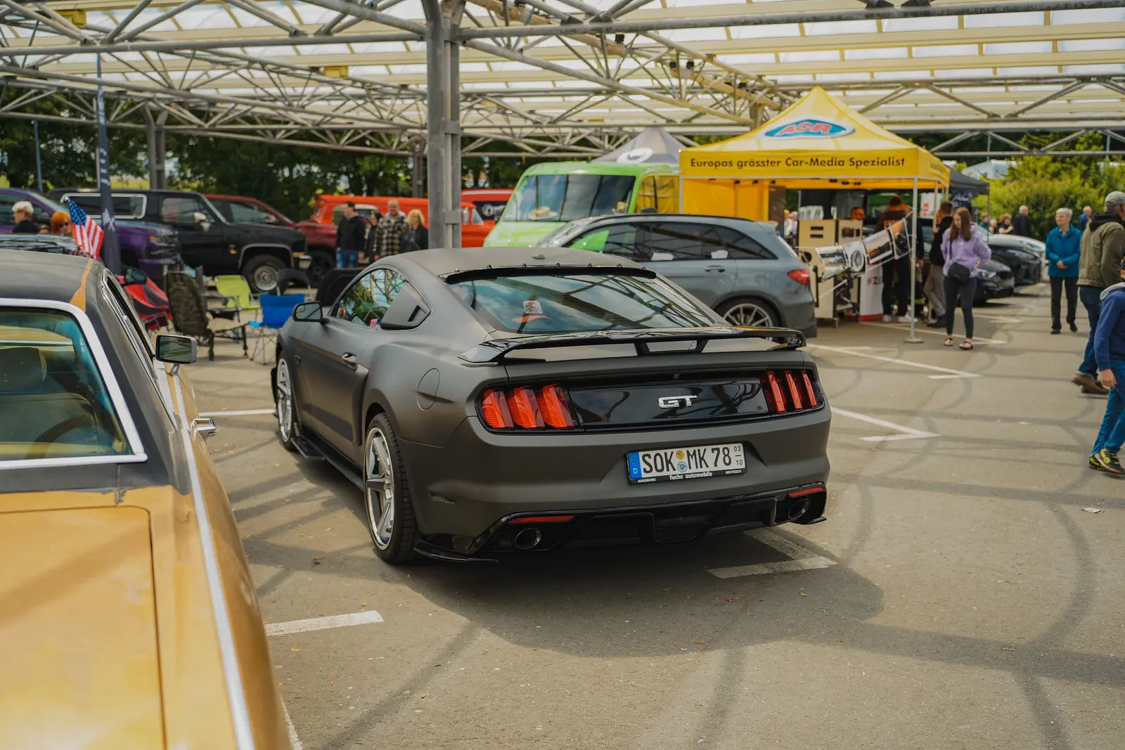 Grauer Mustang GT von hinten auf dem vollen Platz