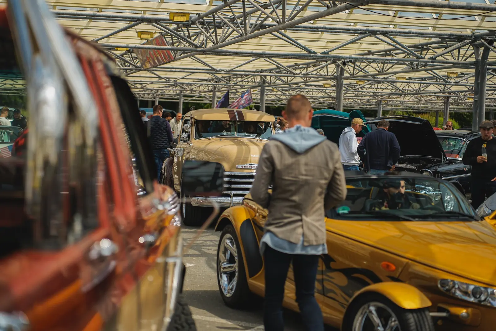 Gelber Plymouth Prowler unter dem Glasdach, vorn ein unscharfer Oldtimer