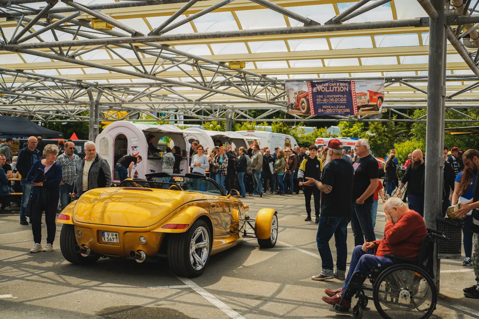 Gelber Plymouth Prowler zwischen Besuchern unter dem Glasdach