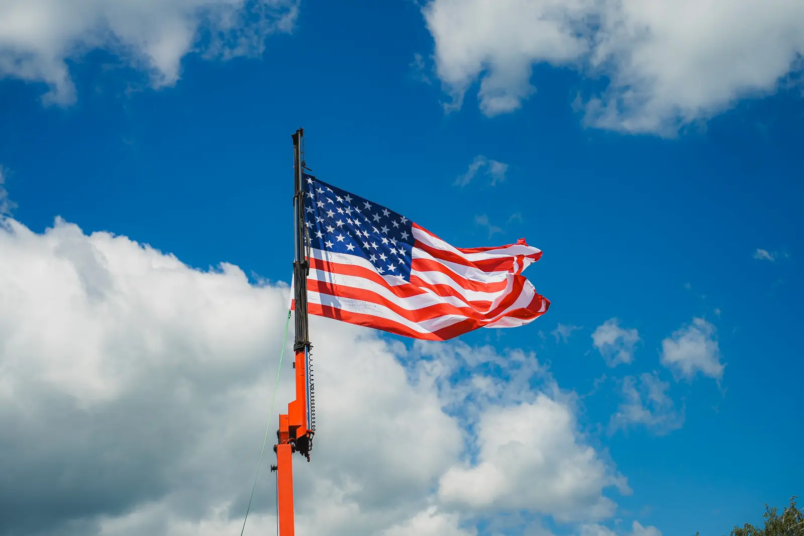 US-Flagge an einem Kranmast vor blauem Himmel