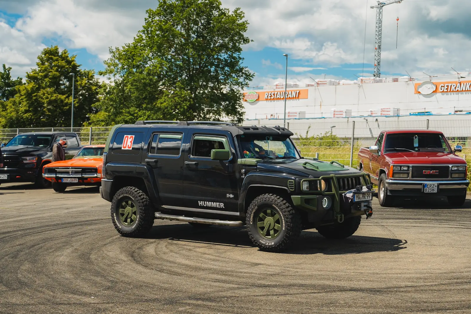 Schwarzer Hummer auf Asphalt mit Reifenspuren