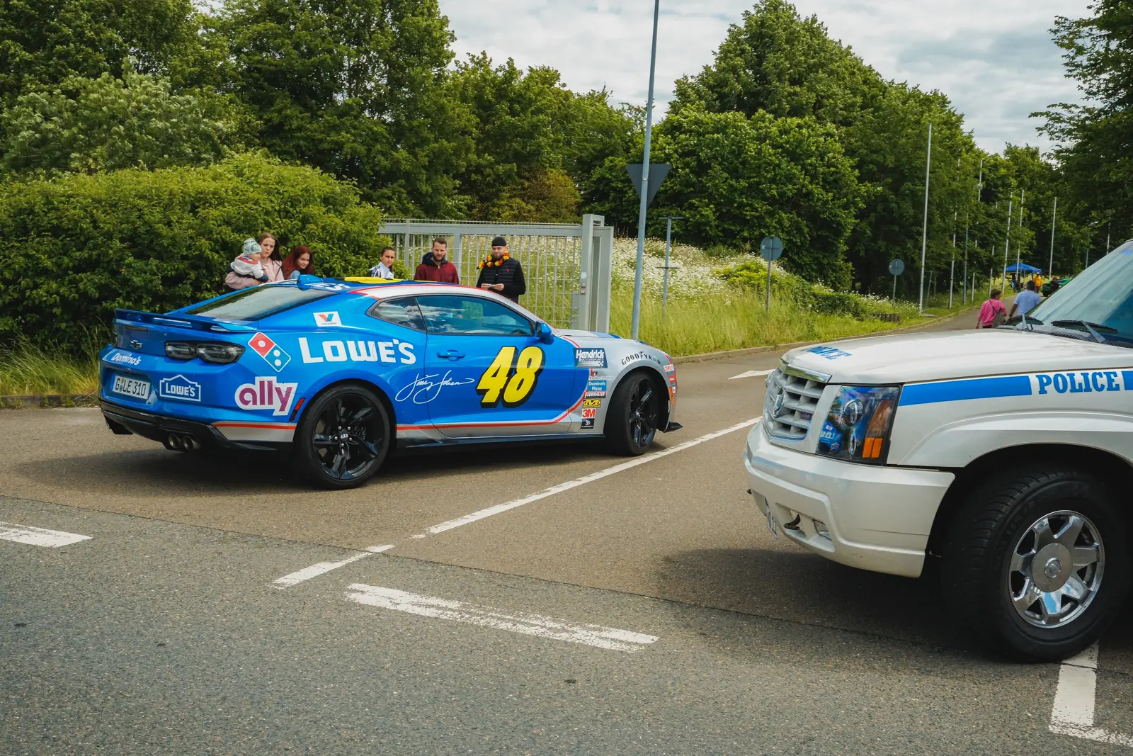 Camaro im Rennwagen-Design mit der Nummer 48 neben einem Polizei-Geländewagen
