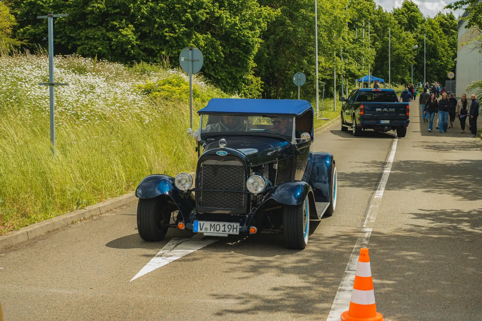 Blauer Hot Rod rollt die Zufahrt entlang