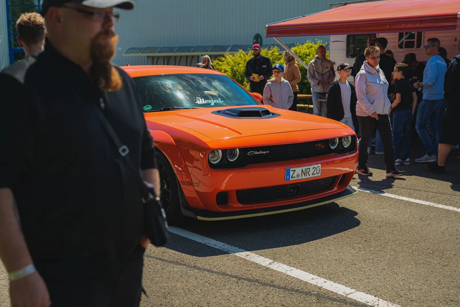 Oranger Dodge Challenger am Imbiss, vorn ein Besucher