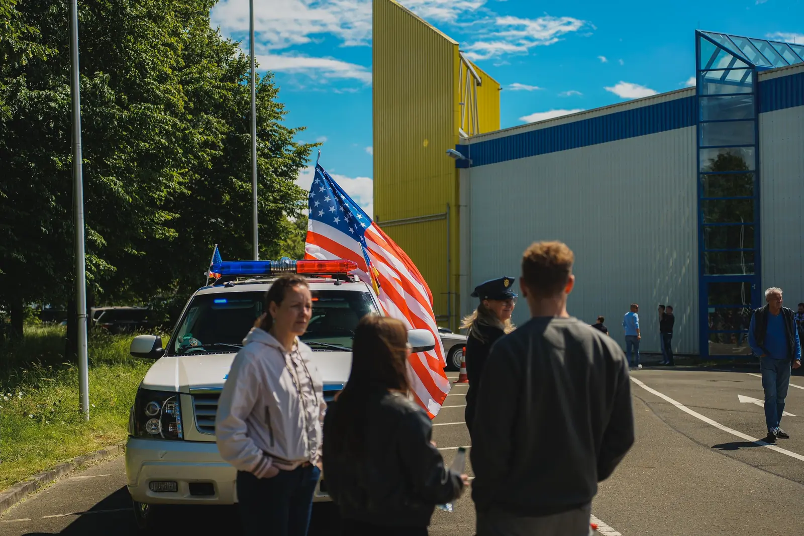 Besucher vor dem Polizei-Geländewagen mit großer US-Flagge