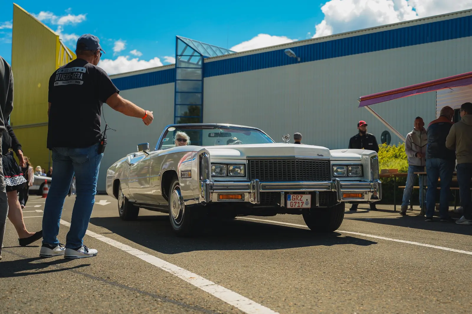 Weißes Cadillac-Cabrio aus den Siebzigern rollt auf den Platz