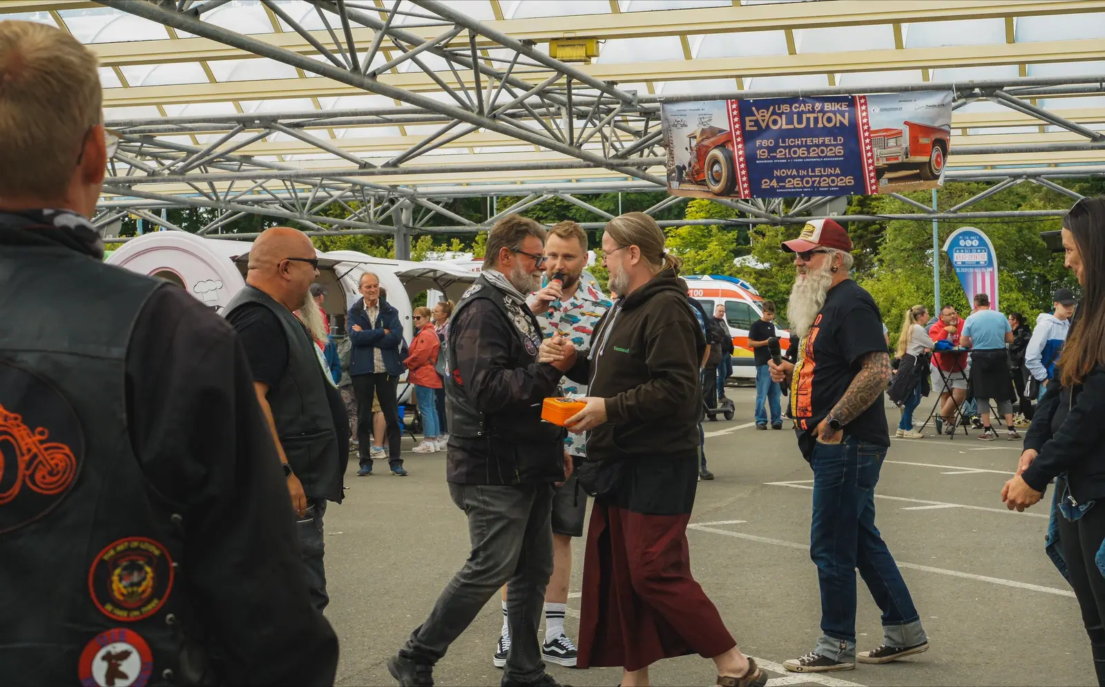 Gäste in Kutten gehen über den Platz zu den Moderatoren