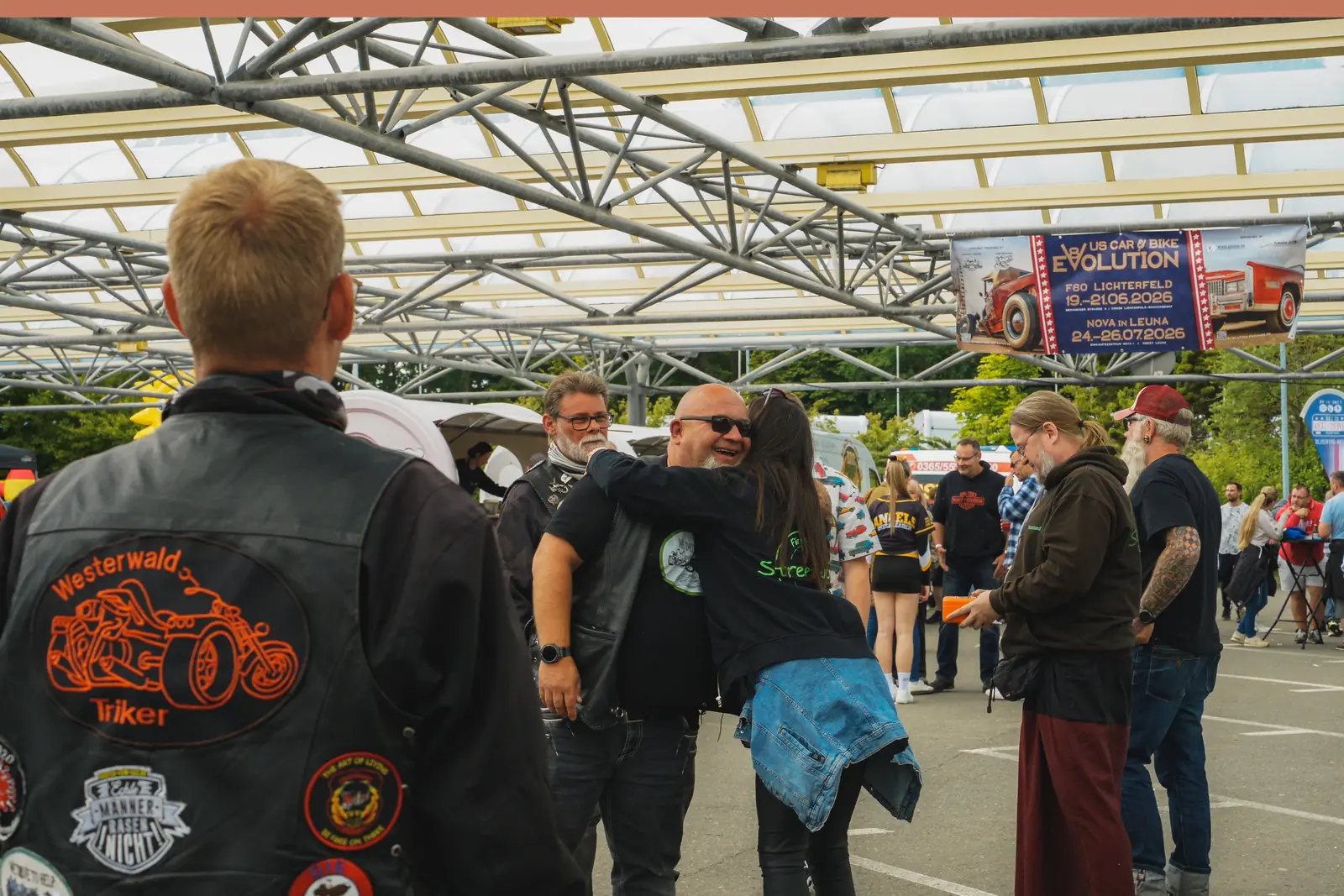 Umarmung vor dem Publikum, vorn ein Biker in Kutte