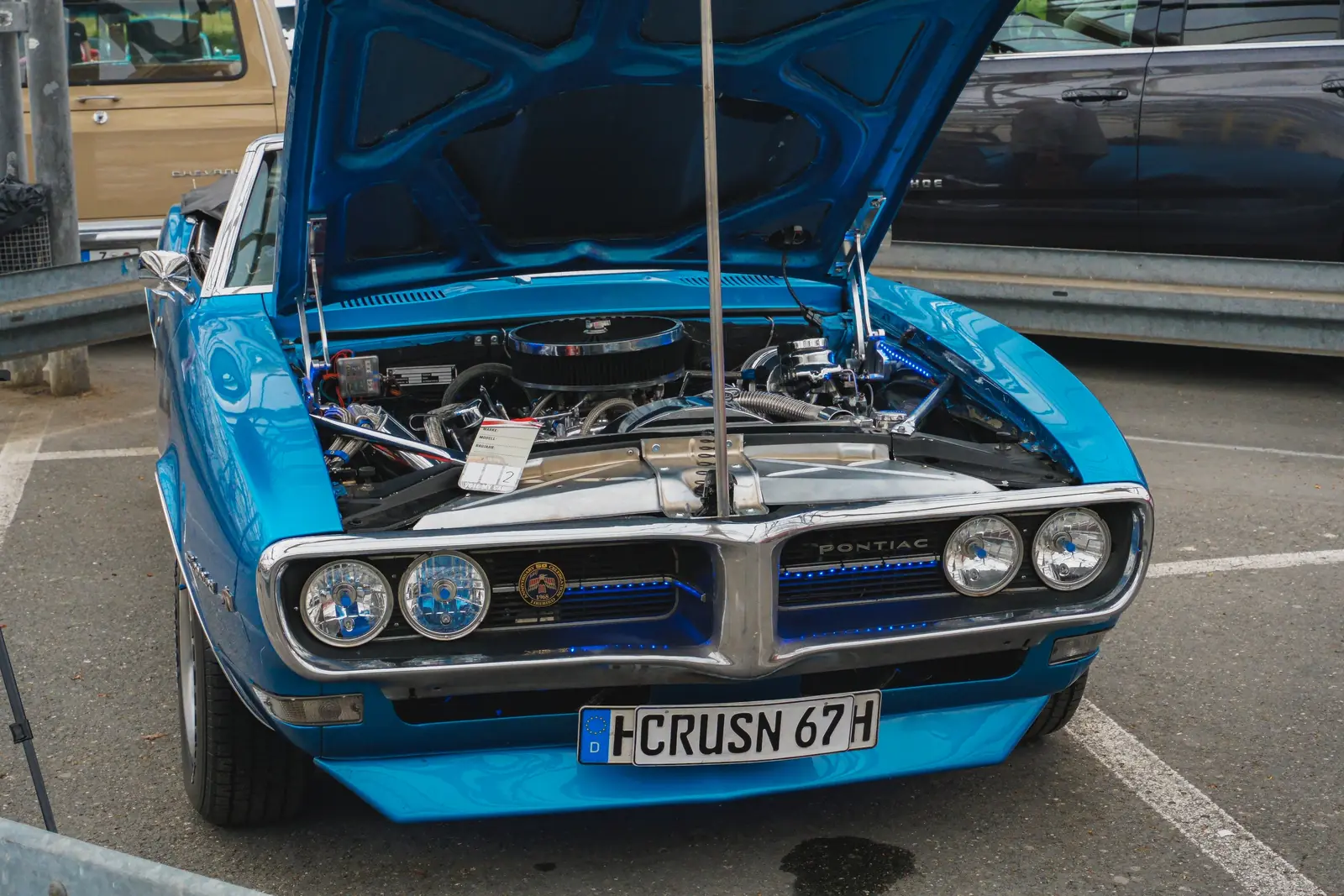 Blauer Pontiac Firebird mit offener Haube, nah von vorn
