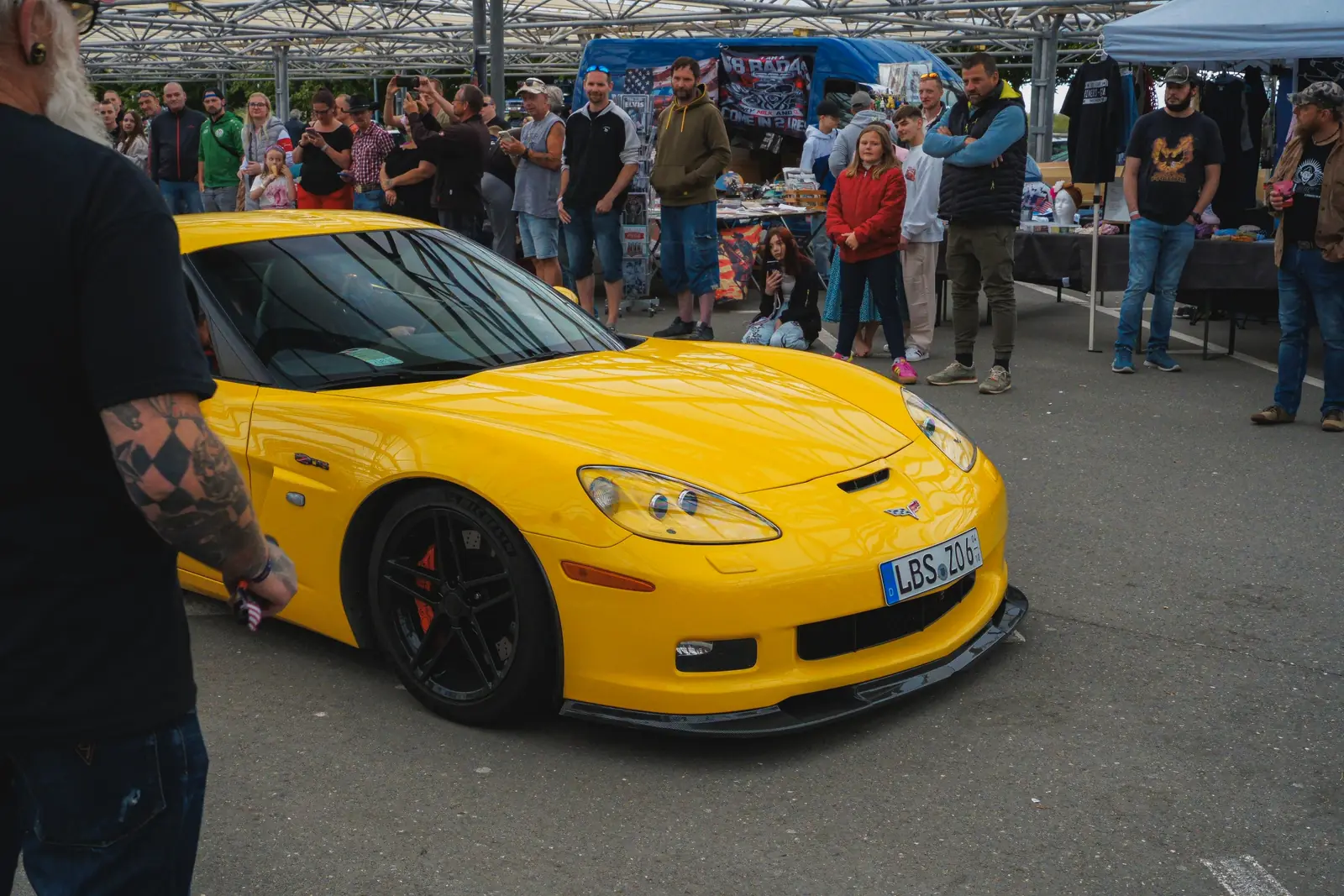 Gelbe Corvette vor Zuschauern und Händlerständen