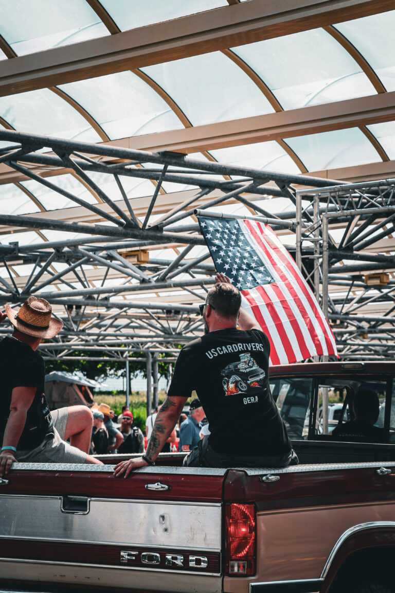 Besucher an einem Pick-up mit US-Flagge