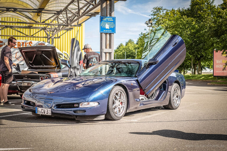 Blaue Corvette mit geöffneten Flügeltüren