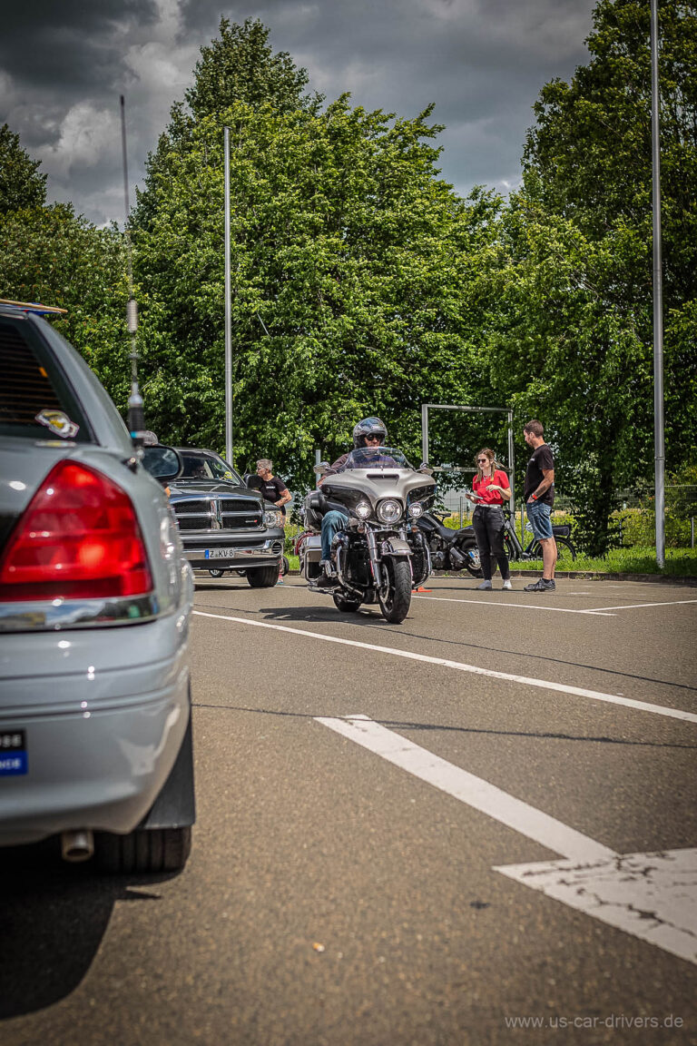 Heck eines silbernen Wagens, dahinter ein Motorrad