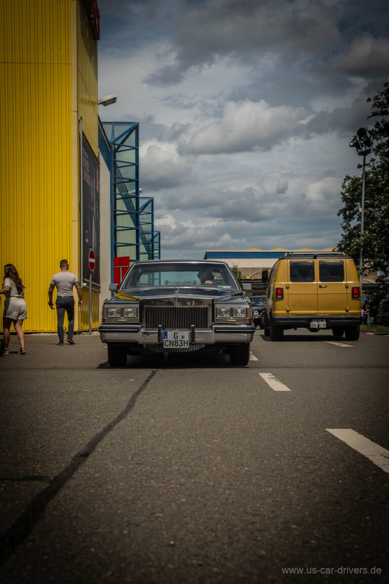 Grauer Oldtimer und gelber Van auf der Zufahrt