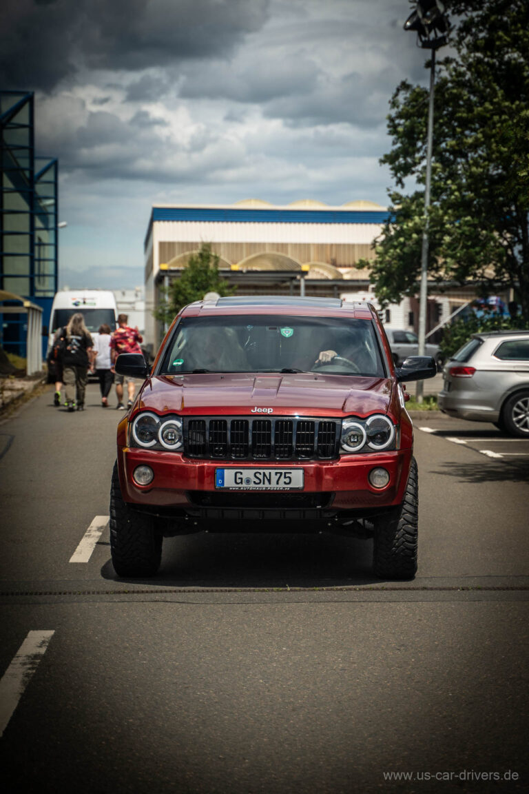 Roter Jeep Grand Cherokee fährt ein