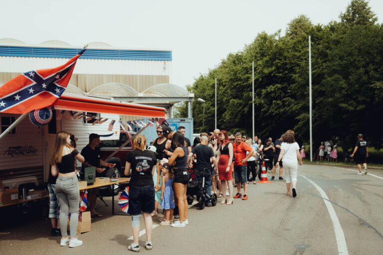 Warteschlange vor einem Stand am Platzrand