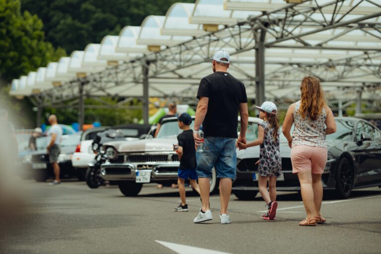 Familie läuft an einem weißen Chevrolet vorbei